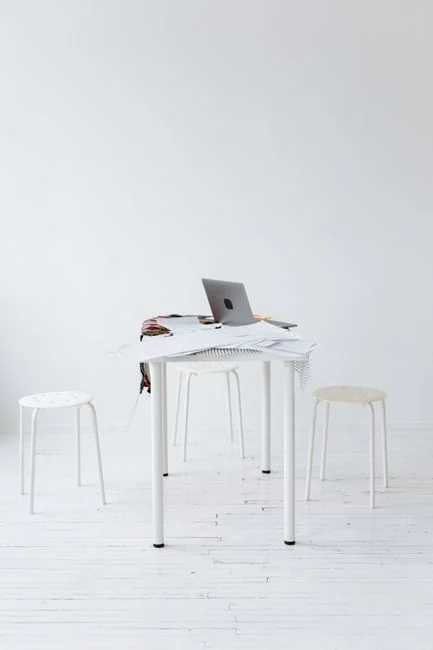 Un espace de travail propre et contemporain, avec un ordinateur portable, une tablette, un smartphone et un écran. Parfait pour le télétravail et les installations technologiques.